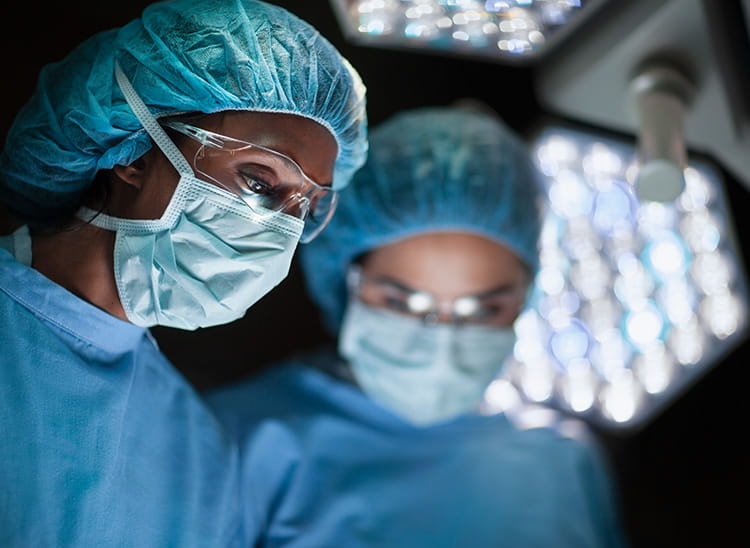 doctors in surgical wear with masks and bonnets