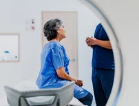 woman sitting near an MRI machine